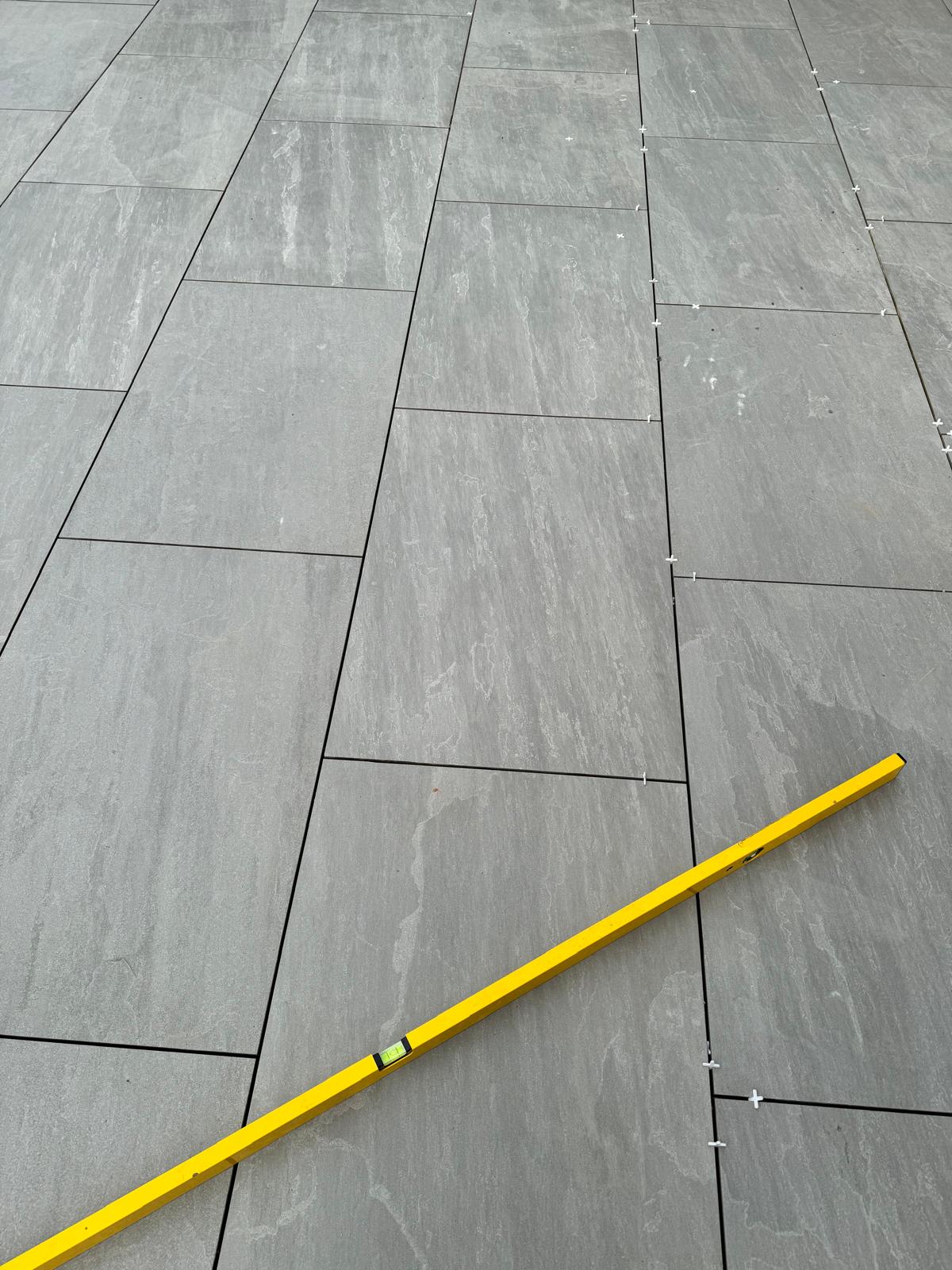 Precision paving installation verified with a spirit level